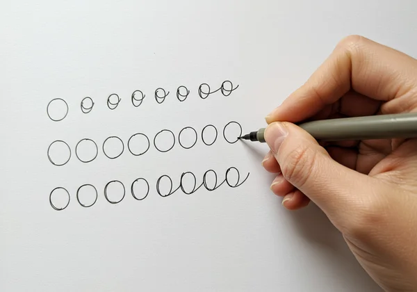 手在练习连接的草书圆圈以保持均匀间距